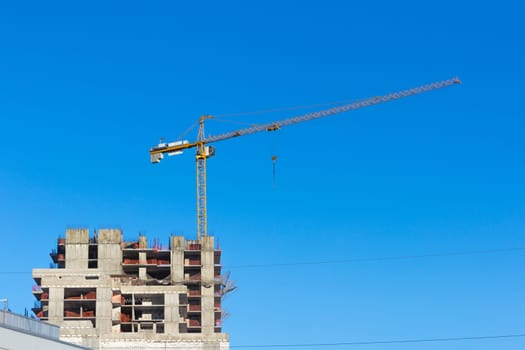 Construction site with two cranes against the sky