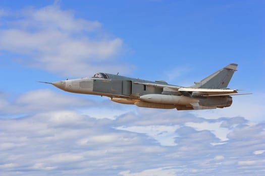 Military jet bomber Su-24 Fencer flying above the clouds.