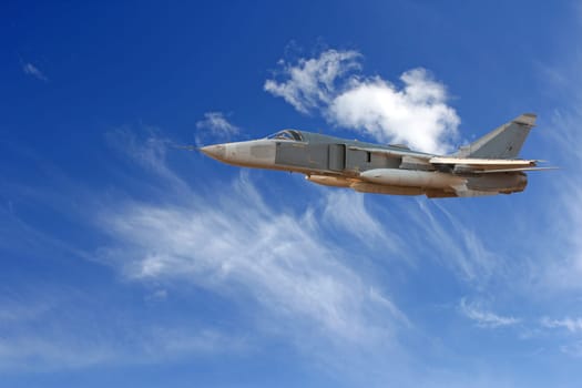 Military jet bomber Su-24 Fencer flying above the clouds.