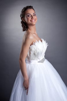 Portrait of happy young bride on gray background, close-up
