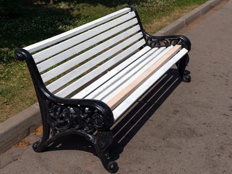 White wooden bench in the park on the street