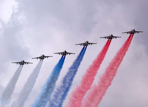 MOSCOW, RUSSIA - MAY 7, 2021: Avia parade in Moscow. Group of Russian fighters Sukhoi Su-25 with painted russian flag in the sky on parade of Victory in World War II in Moscow, Russia
