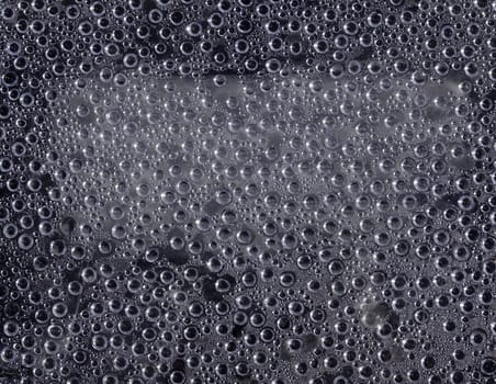 Water droplets gray background on window pane.