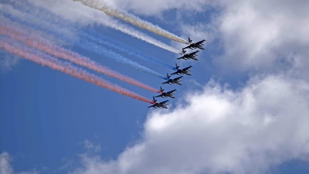 MOSCOW, RUSSIA - MAY 7, 2021: Avia parade in Moscow. Group of Russian fighters Sukhoi Su-25 with painted russian flag in the sky on parade of Victory in World War II in Moscow, Russia