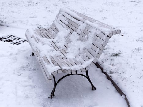 Bench in the park covered with snow.