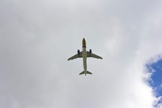Airplane flies against a background of white clouds