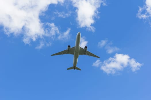 Airplane flies against a background of white clouds