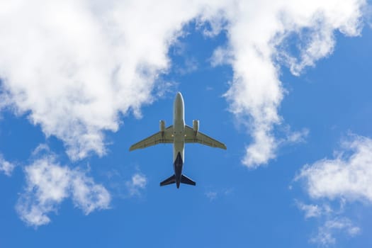 Airplane flies against a background of white clouds