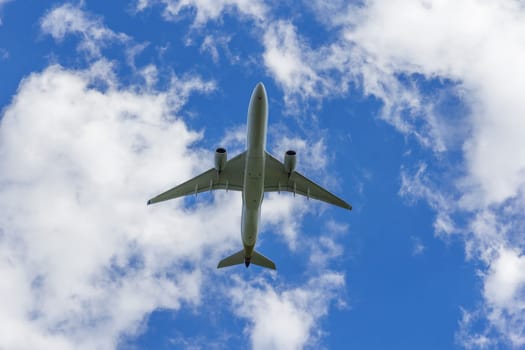 Airplane flies against a background of white clouds