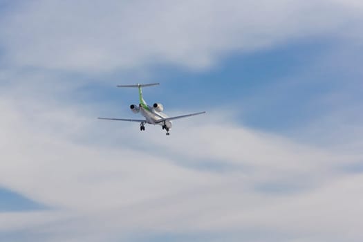 Airplane flies against a background of white clouds