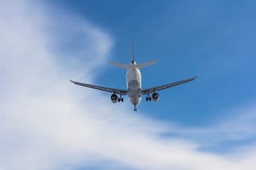 Airplane flies against a background of white clouds