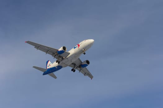 Airplane flies against a background of white clouds