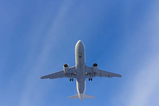 Airplane flies against a background of white clouds