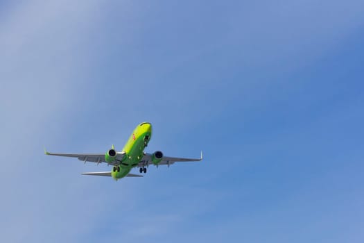 Airplane flies against a background of white clouds