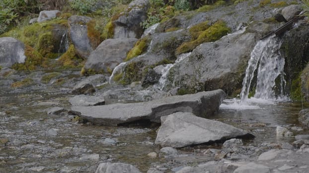 Big beautiful waterfall flows down the rocks mountains.