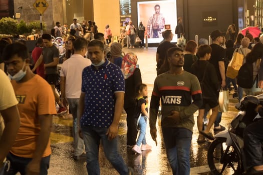March 2, 2023. Bukit Bintang, Kuala Lumpur. People crossing the street at night when raining. Street Photography.