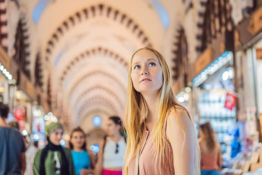 A tourist woman walks among the countless shops at the Grand Bazaar and Egyptian Bazaar in Istanbul. Shopping and travel in Turkey concept. Istanbul historical Egyptian Bazaar. Misir Carsisi, spice market. Turkiye.
