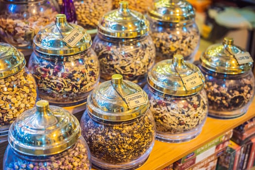 Market counter with different types of tea, herbs, plants, and dried flowers.