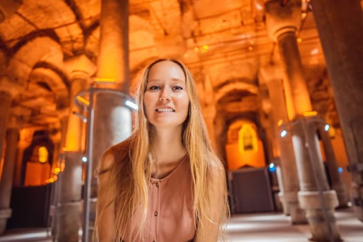 Woman tourist enjoying Beautiful cistern in Istanbul. Cistern - underground water reservoir build in 6th century, Istanbul, Turkey, Turkiye.