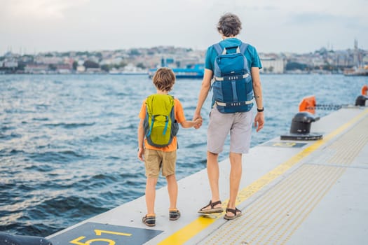 Boy and father tourists enjoying Galataport area view, cruise port of Istanbul newly opening in 2021, located in the shores of the Galata, Karakoy in Istanbul. Traveling with kids concept.