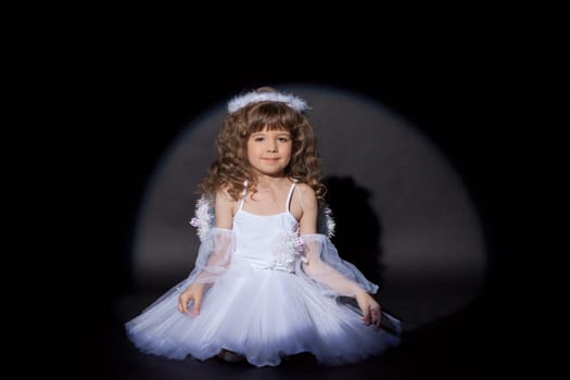 Image of smiling charming angel on black background, close-up
