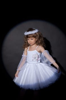 Portrait of adorable angel on dark background, close-up