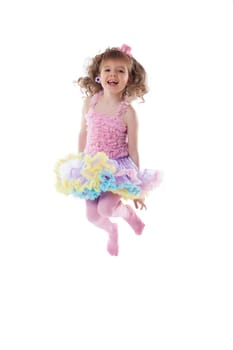 Adorable young girl posing jumping in studio, isolated on white