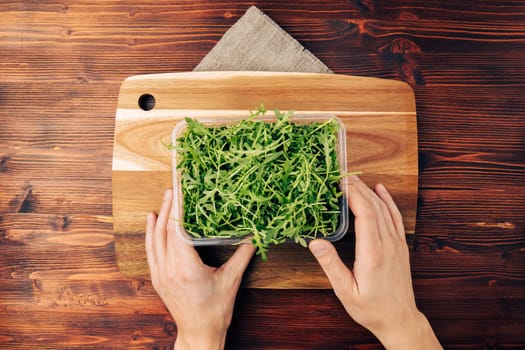 Arugula salad on a wooden board top view. Organically grown ingredients for cooking, the concept of proper nutrition. Flat lay
