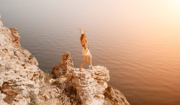 Woman travel sea. Happy tourist taking picture outdoors for memories. Woman traveler looks at the edge of the cliff on the sea bay of mountains, sharing travel adventure journey.