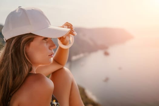 Woman travel sea. Happy tourist taking picture outdoors for memories. Woman traveler looks at the edge of the cliff on the sea bay of mountains, sharing travel adventure journey.