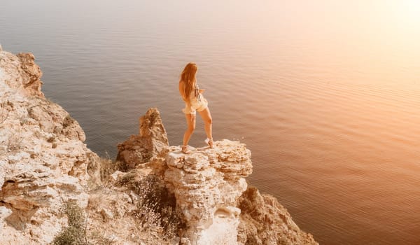 Woman travel sea. Happy tourist taking picture outdoors for memories. Woman traveler looks at the edge of the cliff on the sea bay of mountains, sharing travel adventure journey.