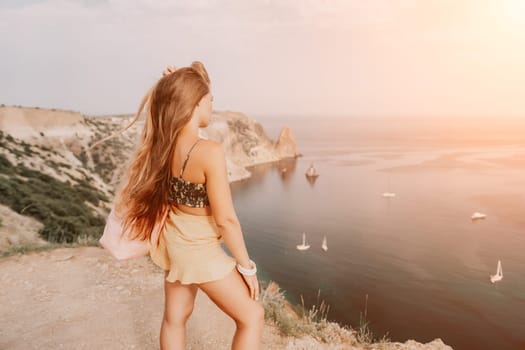 Woman travel sea. Happy tourist taking picture outdoors for memories. Woman traveler looks at the edge of the cliff on the sea bay of mountains, sharing travel adventure journey.