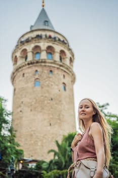 Portrait of beautiful woman tourist with view of Galata tower in Beyoglu, Istanbul, Turkey. Turkiye.