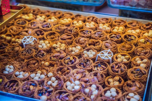 Traditional oriental sweet pastry cookies, nuts, dried fruits, pastilles, marmalade, Turkish desert with sugar, honey and pistachio, in display at a street food market.