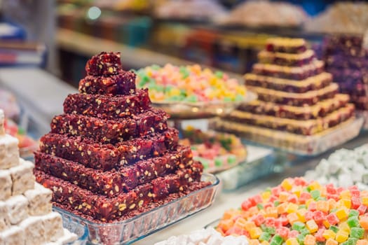 Traditional oriental sweet pastry cookies, nuts, dried fruits, pastilles, marmalade, Turkish desert with sugar, honey and pistachio, in display at a street food market.