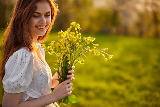 portrait of a woman standing sideways to the camera during sunset with a bouquet of wildflowers. High quality photo