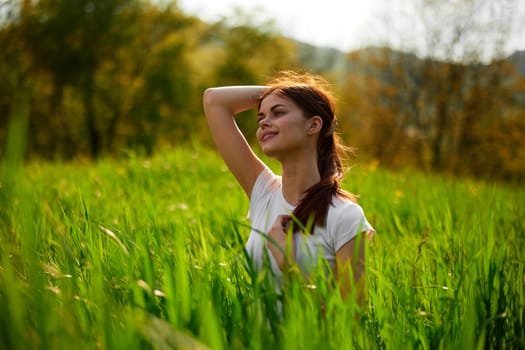 portrait of a pensive redhead woman sitting in the grass at sunset. High quality photo
