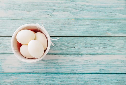 Happy Easter Day Concept. Top view of holiday banner background design white easter eggs and basket on blue wooden background with empty copy space, celebration greeting card