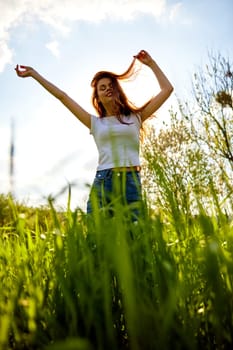 happy woman dancing in high grass field, bottom view. High quality photo