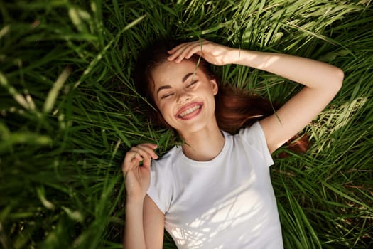 portrait of smiling happy woman with teeth on the grass. High quality photo