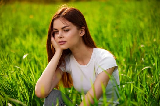 Beautiful young woman close up portrait among green cereal grass. High quality photo