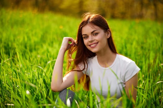 Beautiful young woman close up portrait among green cereal grass. High quality photo