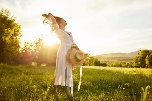 horizontal photo of a woman in a long light dress walking through the forest, illuminated from the back by the rays of the setting sun and straightening her hair. High quality photo