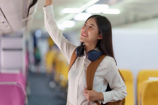 Beautiful Asian traveler woman with backpack when flight is landing. Travel, Airplane concept.