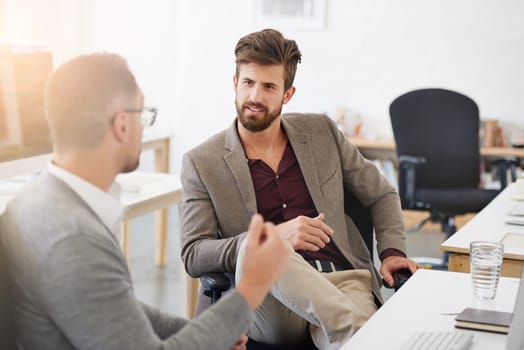 Great communication is key in the workplace. two businessmen having a discussion in the office