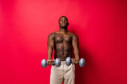 Portrait of happy african man with dumbbells over red and black background