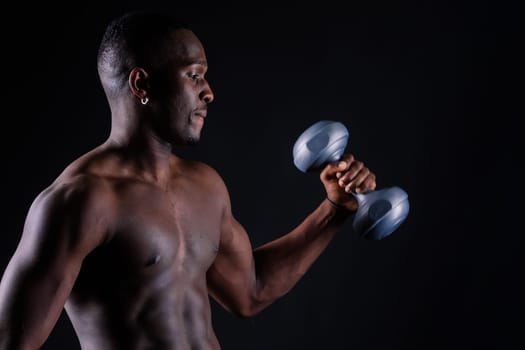 Portrait of happy african man with dumbbells over red and black background