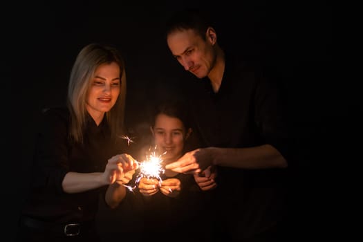 Merry Christmas and Happy Holiday. Family having fun on New Year. family with sparklers.