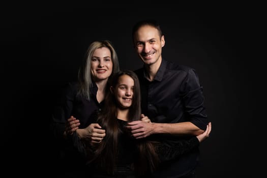 cute little girl and her beautiful young parents looking at camera and smiling.