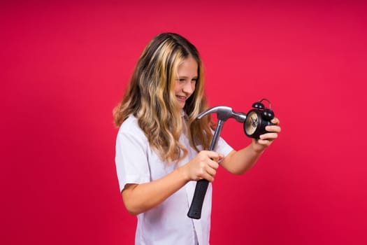 Kid girl holding hammer and alarm clock smiling with happy and cool smile on face. showing teeth.